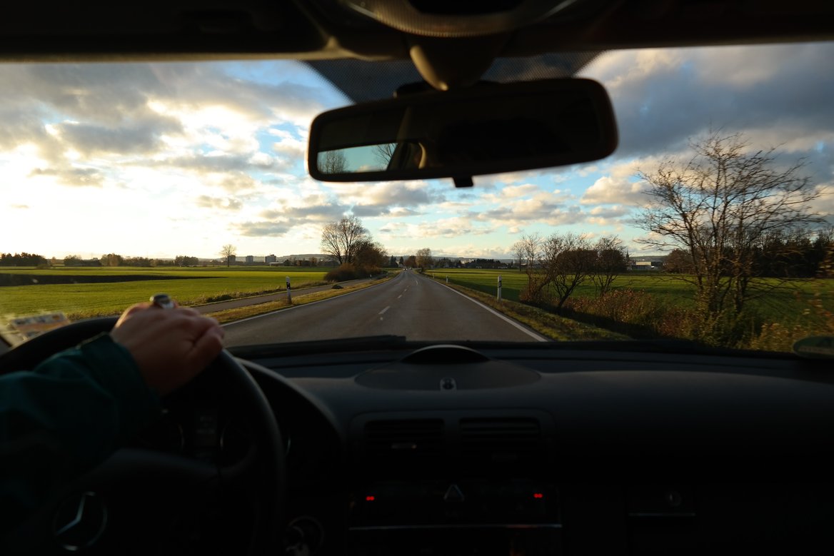View from windshield on a country road at sunrise